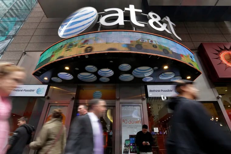 In this 2014 photo, people passed an AT&T store in New York's Times Square.