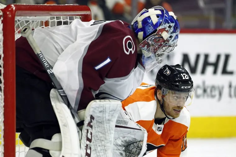 Colorado Avalanche goalie Semyon Varlamov looks at Flyers left winger Michael Raffl who struggles to get up after being checked into the boards by the Avalanches'  Avalanche's Patrik Nemeth on Monday. Raffl will be sidelined four to six weeks with a suspected left-foot injury.