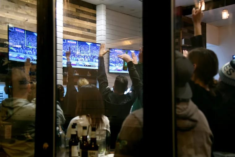 Eagles fans watching TV at the Blue Duck, a Center City bar on South Broad Street celebrate as Eagles’ Jake Elliott kicks a 38-yard field goal to end the first half of the NFC Championship game January 21, 2018.