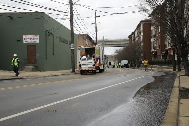 Philadelphia Water Department crews work to fix the water main break at Scotts Lane and Ridge Avenue on Friday.