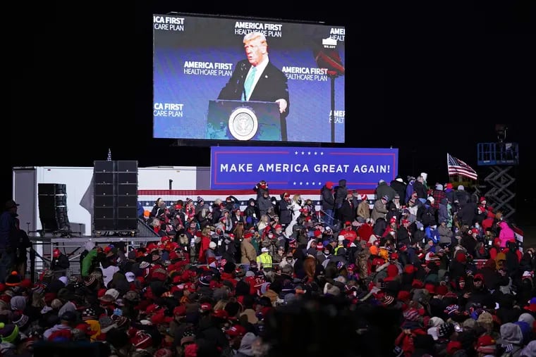 President Donald Trump is projected on a large screen as supporters wait for his arrival to a campaign rally in Omaha, Neb., on Tuesday.