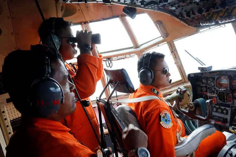Searchers scan the horizon from an Indonesian air force plane flying over the Karimata Strait. The AirAsia jet they were looking for was flying from Surabaya, Indonesia, to Singapore when it disappeared Sunday.