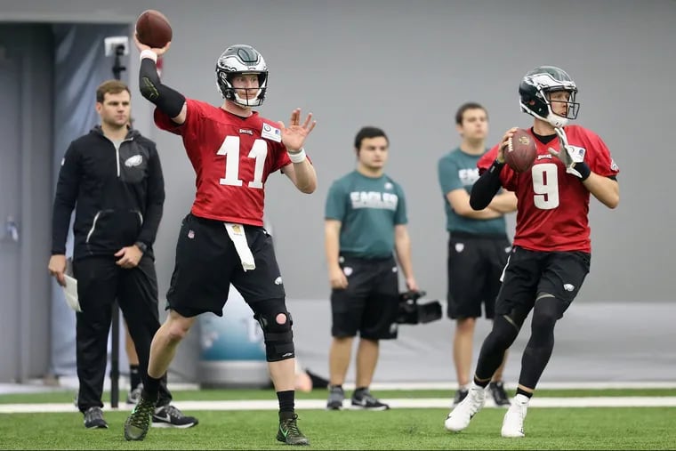 Eagles quarterbacks Carson Wentz (11) and Nick Foles (9) throwing passes during practice in May.