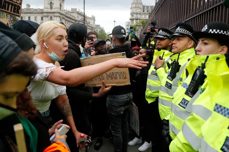 A protester yells at police during the Black Lives Matter protest rally in London, Sunday, June 7, 2020, in response to the recent killing of George Floyd by police officers in Minneapolis, USA, that has led to protests in many countries and across the US.