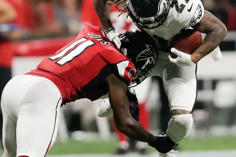 Eagles cornerback Ronald Darby is hit by Atlanta's Julio Jones after Darby intercepted the ball.