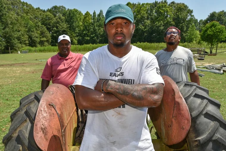 Eagles running back Kenny Gainwell (center) and his father Curtis Gainwell (left) and brother Curtis Gainwell Jr., stand on their farm near Benton, Mississippi back in July.