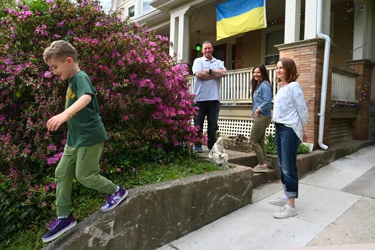 Richard McIlhenny and Marissa Vergnetti (rear) outside their Mount Airy home, where they are hosting Veronika Pavliutina (right) and her son, Yegor (left), 8.