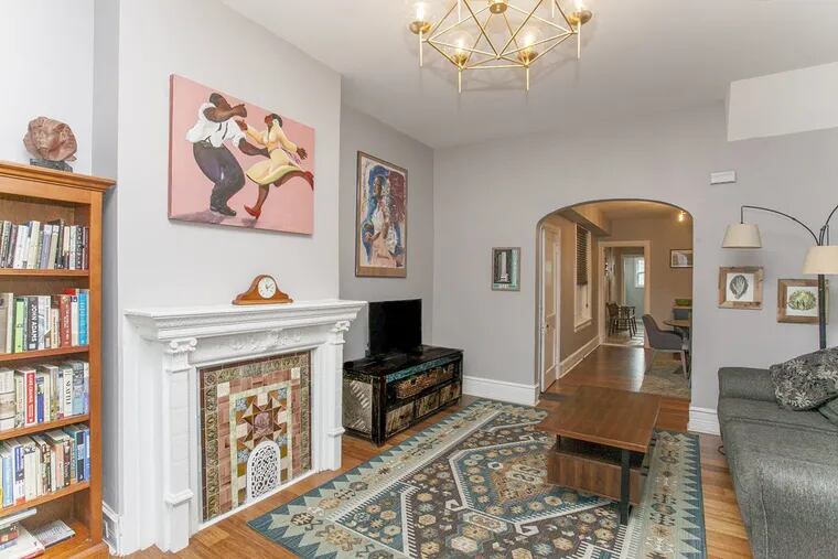 The living room is centered on an antique mantle and is adjacent to a separate dining area.