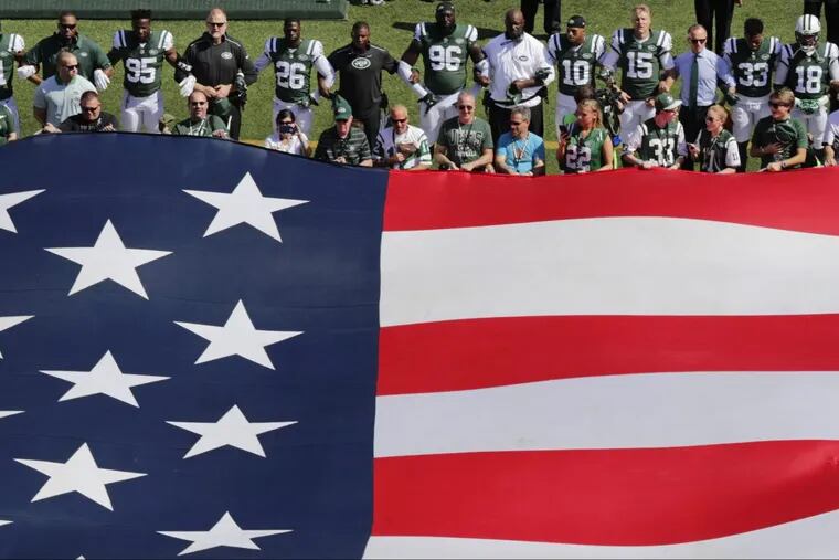 The New York Jets lock arms during the playing of the national anthem before their Sept. 24 game against the Miami Dolphins.