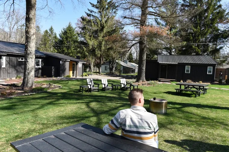 Brian Linton sits at a picnic bench on the grounds of The Rex Hotel in Greentown, Pa. Linton and his wife, Joanna Linton, opened the boutique hotel that borders Promised Land State Park in July of 2021.