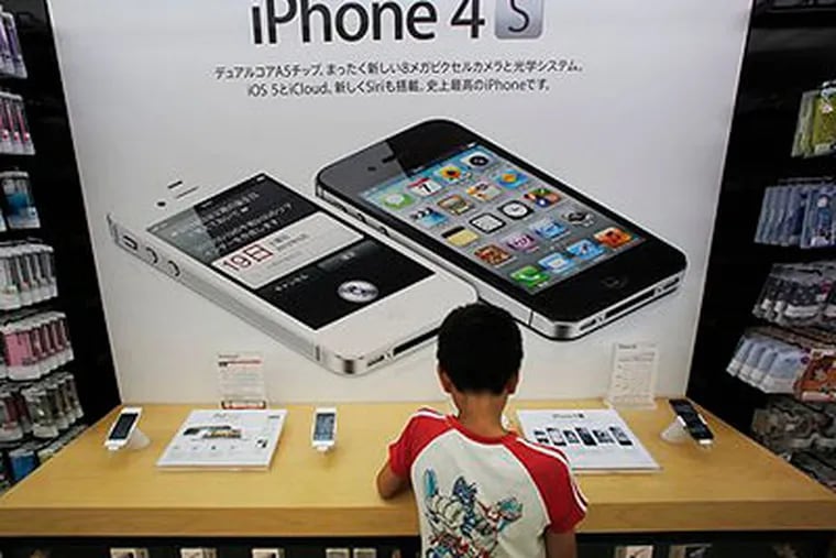 In this Friday, Aug. 31, 2012 file photo, a boy checks an iPhone at an Apple booth at an electronic store in Tokyo. Millions of people will likely buy new iPhones after Apple's expected announcement of a new model on Wednesday, Sept. 12, 2012. The new phones would join some 244 million iPhones already sold since the first one launched in 2007. (AP Photo / Itsuo Inouye, File)