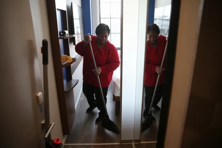 Housekeeping manager Carolyn Aduhene sweeps the floor in a room at the Pod Hotel in Washington, D.C., on Wednesday, Feb. 14, 2018. A new New Jersey law will mandate panic buttons for hotel housekeepers.