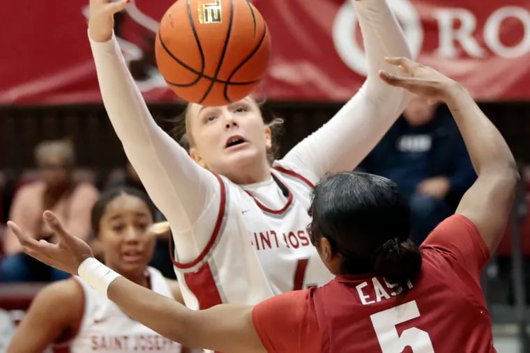 St. Joe’s Laura Ziegler and Temple’s Tiarra East fight for a rebound during Wednesday's game. Ziegler finished with 10 points and eight rebounds in the Hawks win.