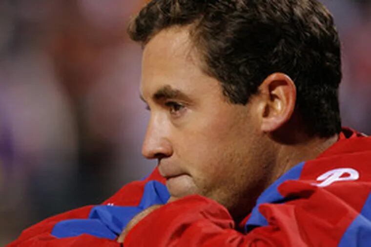 Phillies leftfielder Pat Burrell watches from the bench. His problems have created interesting dilemmas for manager Charlie Manuel and GM Pat Gillick.