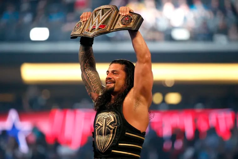 Roman Reigns holds up the championship belt after defeating Triple H during WrestleMania 32 at AT&T Stadium in Arlington, Texas, in 2016.