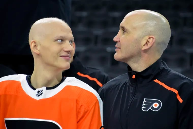 Left winger Oskar Lindblom (left), who is undergoing cancer treatments, with assistant coach Ian Laperriere at the Flyers' team photo session on March 9 -- three days before the season was stopped.