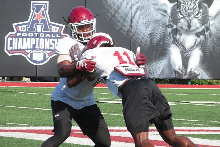 Temple's Ayron Monroe, takes on teammate Linwood Crump (11) in a blocking drill at Friday's practice.