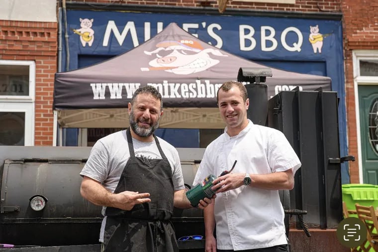 Mike Strauss (left) literally passing the torch to Daniel Grobman, who is buying Mike's BBQ, 1703 S. 11th St.