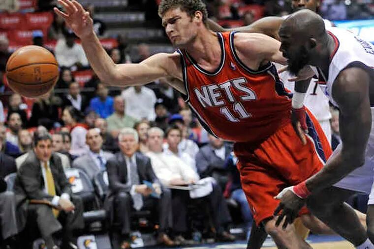 Nets' Brook Lopez and Sixers' Reggie Evans battle for a loose ball in the first half of New Jersey's blowout win.