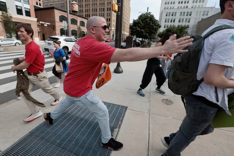 John Welsh School teacher Peter Doherty tags another teacher while paying Sicko tag during a rally to discontinue the "3-5-7-9" policy, which penalizes them for taking earned sick days, outside the Philadelphia School District headquarters on Thursday.