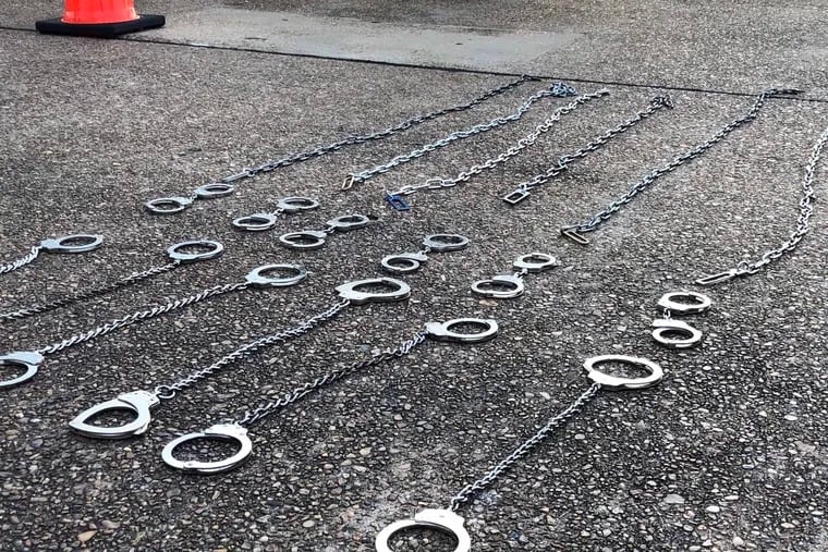 Shackles lie on the tarmac at an airfield in Alexandria, Louisiana, after ICE agents loaded deportees onto a flight to Guatemala. Handcuffs are typically removed from Guatemalan deportees about an hour before their flight lands, according to ICE. Leg restraints are removed when deportees board the plane.