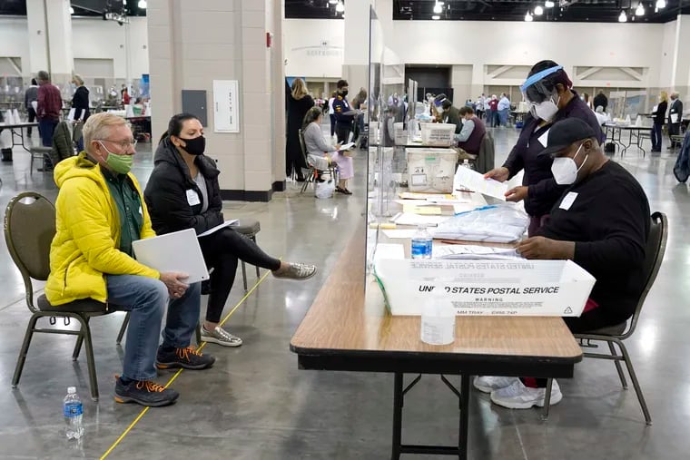 In this Nov. 20 photo, election workers, right, verify ballots as recount observers, left, watch during a Milwaukee hand recount of presidential votes at the Wisconsin Center in Milwaukee.