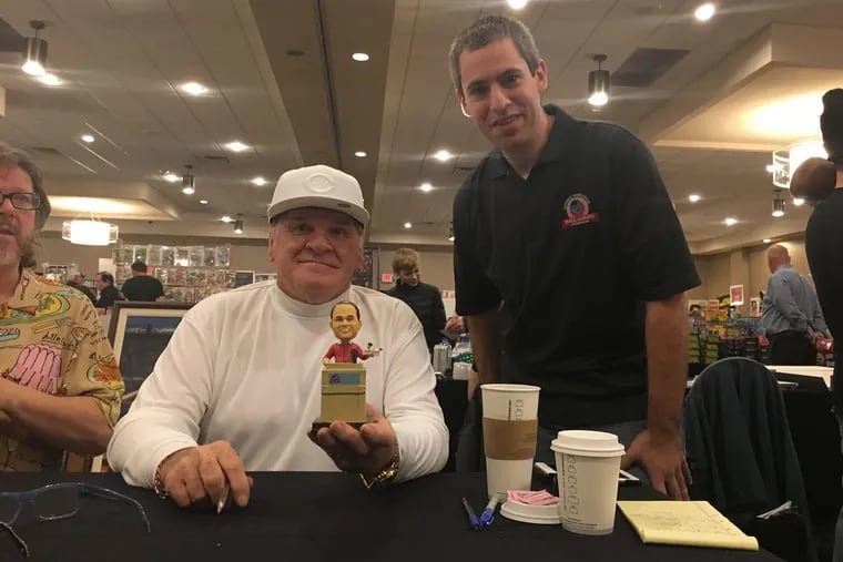 Pete Rose, holding his bobblehead, sits beside National Bobblehead Hall of Fame and Museum cofounder Phil Sklar.
