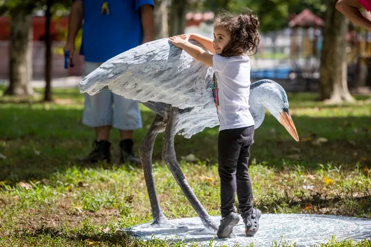 Elaine Ortiz, 2, with Great Blue Heron created by sculpture artist Miguel Horn (not shown) Miguel unveiled the Great Blue Heron for Elaine at Tacony Creek Park.