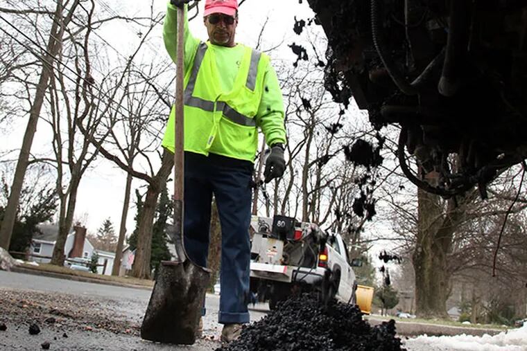 James Nunn from the Cherry Hill Public Works Department repairs a pothole with asphalt from a dump truck at Pearlcroft and Borton Mill Roads in Cherry Hill, NJ on Tuesday, March 2, 2010.  (Laurence Kesterson / Staff Photographer)