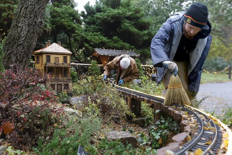 Micah Christensen, right, and Vince Marrocco, left, work on the holiday display in the Garden Railway at Morris Arboretum in Philadelphia, PA on November 13, 2018. DAVID MAIALETTI / Staff Photographer