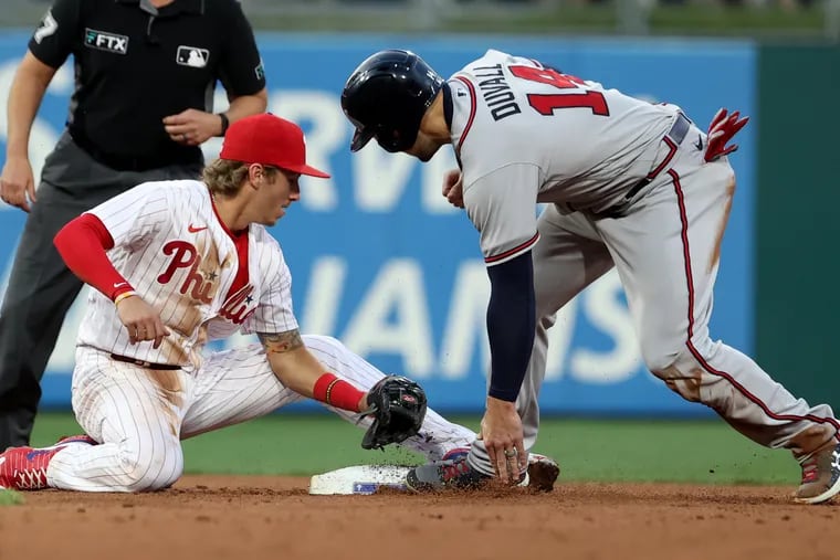 Bryson Stott, left,  of the Phillies tags out Adam Duvall the Braves ashe tried to steal 2nd base on June 29, 2022.