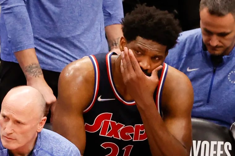 Sixers center Joel Embiid sits on the bench after taking an elbow to his face against the Toronto Raptors late in the fourth quarter of Game 6.