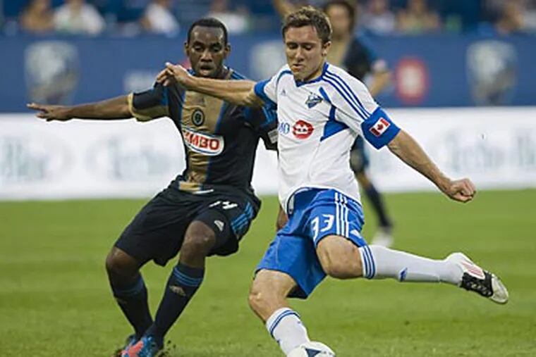 Amobi Okugo moves in on the Impact's Andrew Wenger during first half on Saturday. (AP/The Canadian Press)