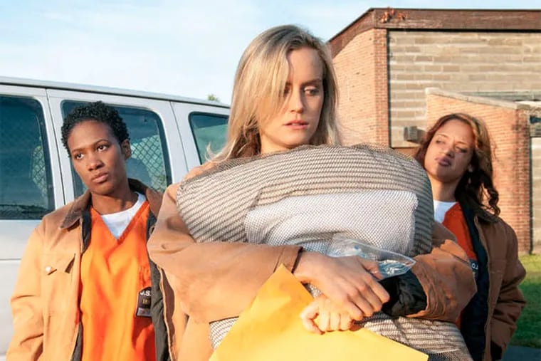 Taylor Schilling (front) is the sheltered Piper Chapman, whose new address is prison. Costarring are Vicky Jeudy (left) and Dascha Polanco.