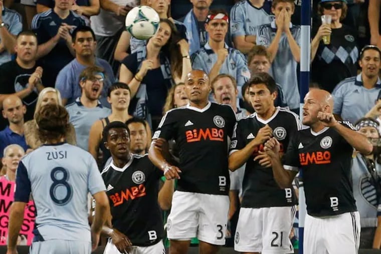 Union midfielder Michael Lahoud (13), defender Fabinho (33), midfielder Michael Farfan (21) and forward Conor Casey (6) try to block a free kick during the first half of an MLS soccer match against Sporting KC in Kansas City, Kan., Friday, Sept. 27, 2013. (Orlin Wagner/AP)