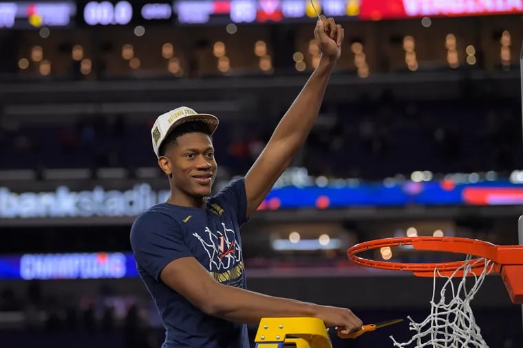 Virginia’s De’Andre Hunter holds up a piece of the net after his team’s win in the NCAA championship game on Monday. Hunter scored a career-high 27 points.
