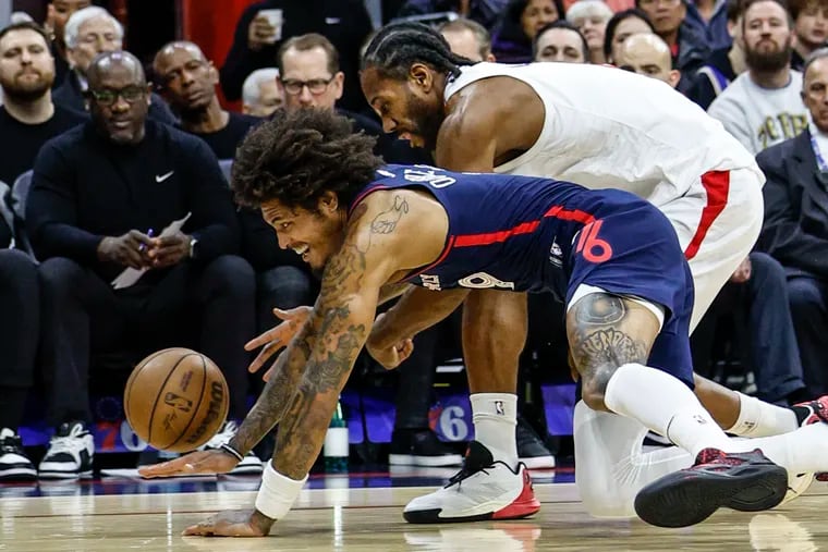 Kelly Oubre Jr. (left) of the Sixers and the Clippers' Kawhi Leonard dive for a loose ball during the first quarter Wednesday.