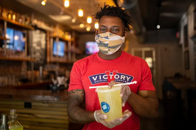 Kendrick Worth, 27, of Brick, N.J., manager at Wrap Shack, poses for a portrait with a margarita on Wednesday, May 27, 2020. “We’re doing pretty well,” Worth said. "We have a safe environment and a safe system in place. It’s always nice to see our regular people and provide for the community.”