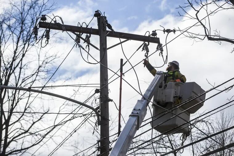An electrical worker repairs power line on Old Gulph Road in Bryn Mawr during a storm in March.