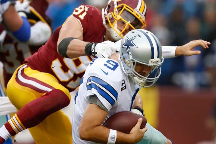Cowboys quarterback Tony Romo is sacked by Washington Redskins outside linebacker Ryan Kerrigan during the second half of an NFL football game in Landover, Md., Sunday, Dec. 22, 2013. (Evan Vucci/AP)