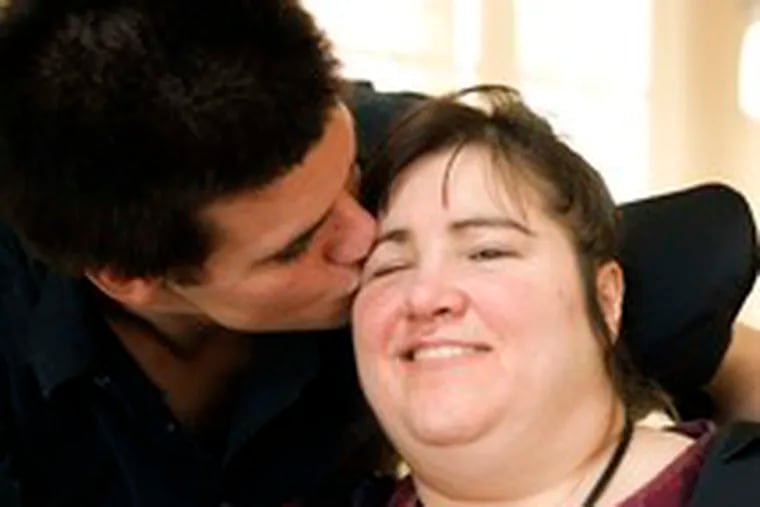 Andrew Hill kisses his mother, Kim, whose childhood battle with leukemia resulted years later in brain tumors.