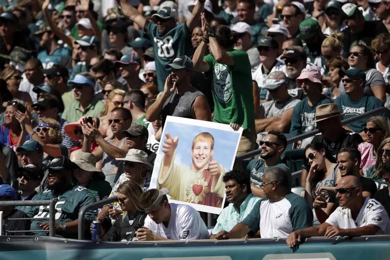 Fans hold up a sign of Eagles quarterback Carson Wentz during the first half of the game against the New York Giants on Sept. 24.