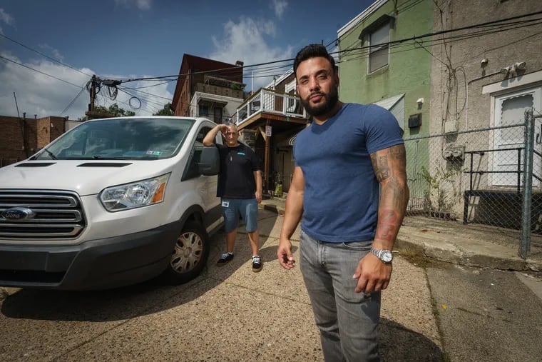 Mauro Falaschetti, front, Philadelphia Recovery Residences owner, provides transportation to AA ad NA meetings for residents. He is shown here with volunteer Robert Bostley, back left, and his vehicle in the parking spot behind his recovery house in South Philadelphia.