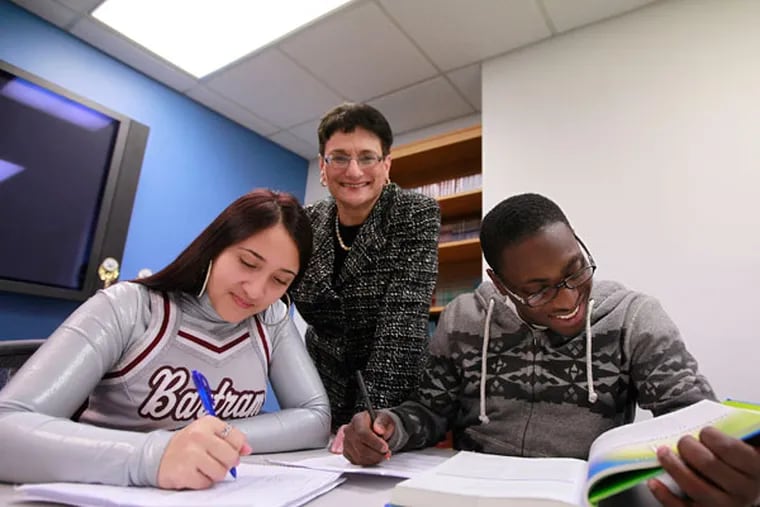 Selena Trammell, 17 and Kareem Belgrave, 17 work on their homework. Standing, Joan Mazzotti, director of Philadelphia Futures, the local organization that provides intense college prep, counseling, and support for kids from Philadelphia public schools received a $1 million check across her desk. That's the reason behind a brand-new program that will help hundreds more Philly high schoolers get to, stay and be successful in, and have manageable debt upon completion of college.( DAVID SWANSON / Staff Photographer )