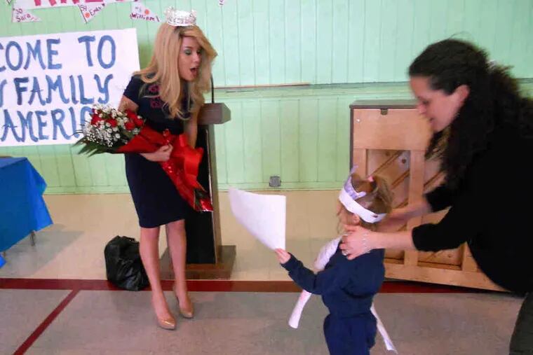 Stella Smith, a kindergartner at Holy Family Regional School in Ventnor, N.J., hands Miss America Teresa Scanlan a birthday card. Stella's mother, Fotene, offered support. Scanlan turns 18 next Sunday. (See &quot;The circuit.&quot;)