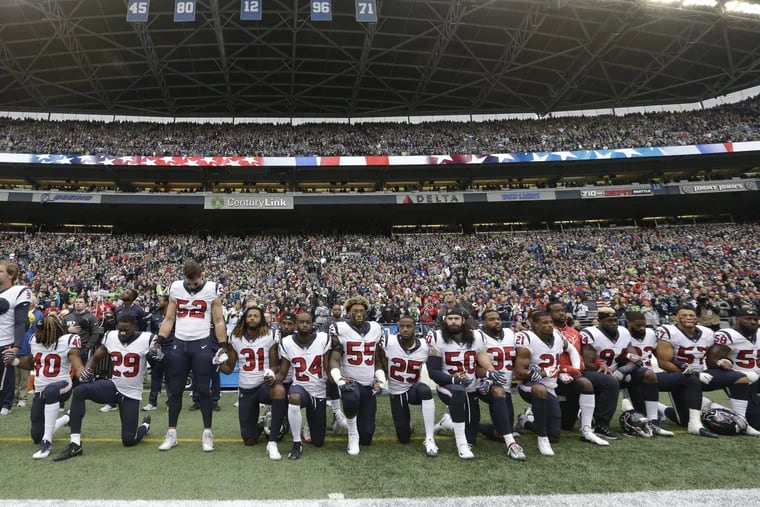 Houston Texans players protest during the singing of the national anthem before an NFL football game against the Seattle Seahawks, in Seattle last year.