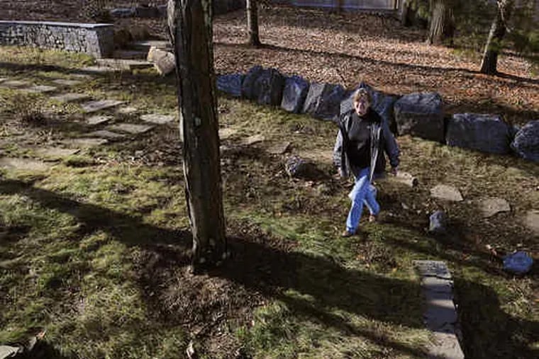 Maureen Carbery , cofounder of an environmental group, crosses her lawn in Villanova. She replanted it in a mix of &quot;no-mow&quot; fescues that will give it, with time, a meadowy look.