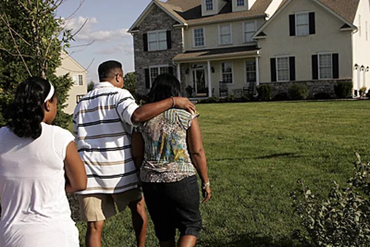 SEPTA Police Sgt. Darryl Simmons, center, walks with his family to their house. He says he shot and killed Joseph McNair in self-defense. (Michael Perez / Inquirer)