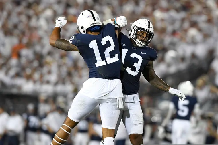 Penn State linebackers Brandon Smith (12) and Ellis Brooks (13) celebrate a stop against Auburn during an NCAA college football game in State College, Pa., on Saturday, Sept. 18, 2021.