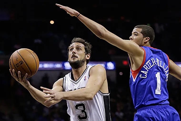 The Spurs' Marco Belinelli drives around the 76ers' Michael Carter-Williams. (Eric Gay/AP)